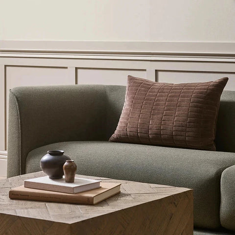 Chocolate quilted cotton velvet lumbar cushion with brickwork texture, styled on a sofa