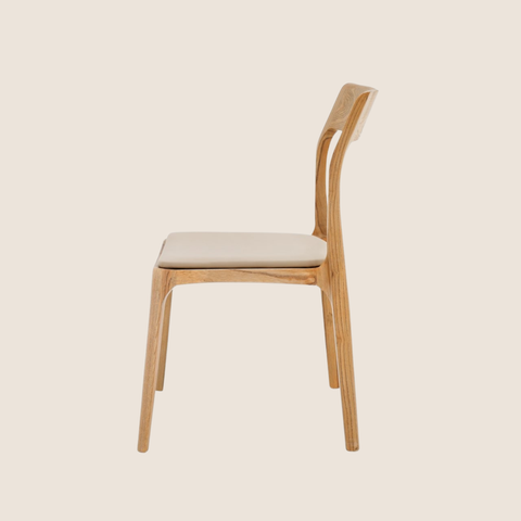 Close-up of curved backrest and leather seat detail on the Cove dining chair