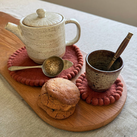 Close-up of felt-ball edge detail on spiced cocoa coaster