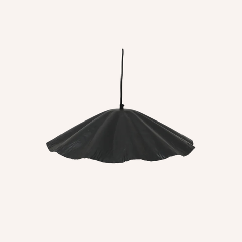 A black dome pendant light shade suspended by a thin black cord against a solid off-white background.