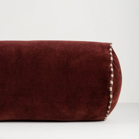Close-up of Elliot Oxblood Bolster Cushion showing cotton velvet texture and striped linen piping