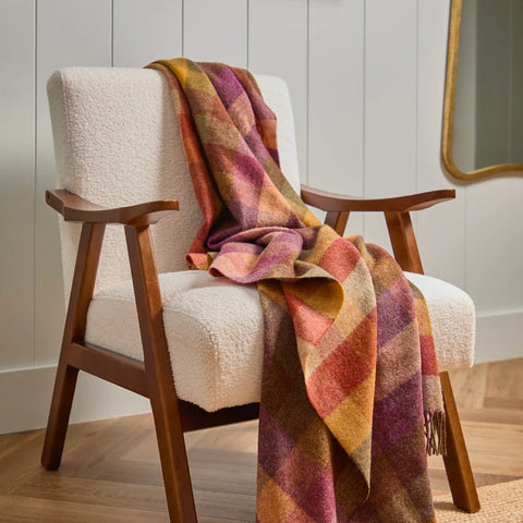 Harlequin Autumn NZ Wool Throw styled on an armchair