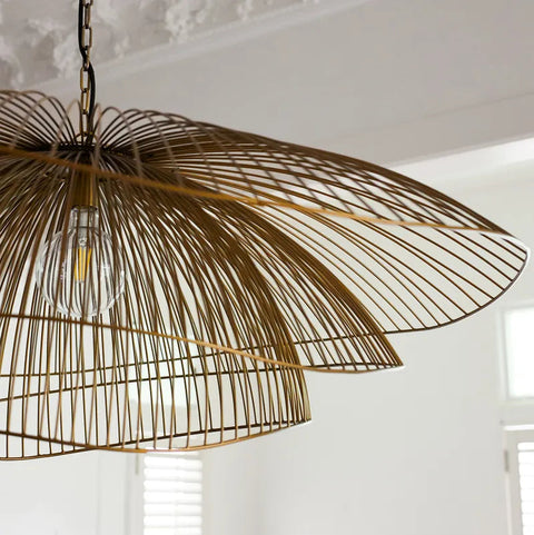 Decorative pendant light with wicker design in a room with white walls and a window.