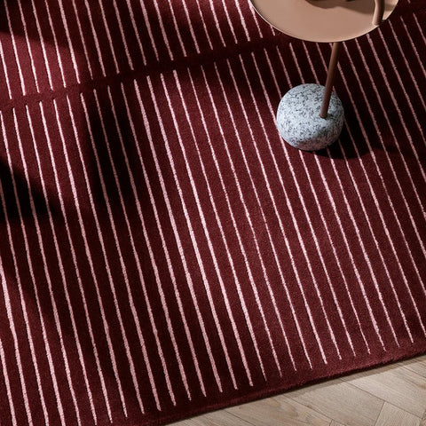 Marlow Wine Rug in burgundy and pale pink styled in a living room