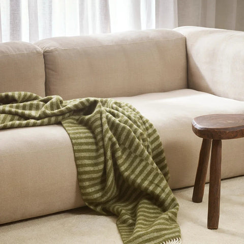 Noah Olive Throw draped over a sofa
