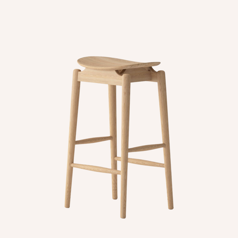 A light natural wood bar stool with a curved seat, four tapered legs, and front support bars, shown on a plain off-white background.