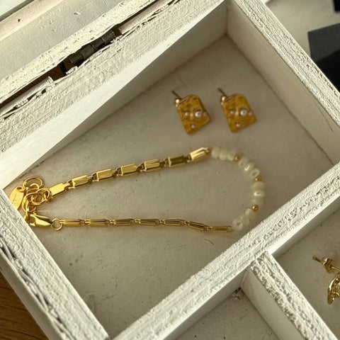 Pearl + Chain gold bracelet in a white wooden jewellery box beside matching pearl earrings