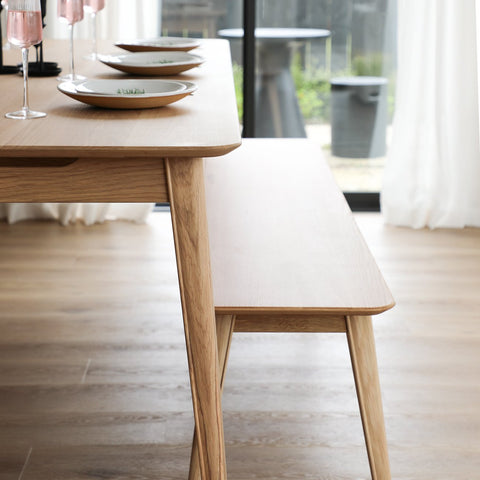Wooden dining table with plates and glasses in a bright room