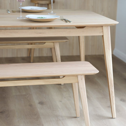 Wooden dining table with bench in a minimalistic setting