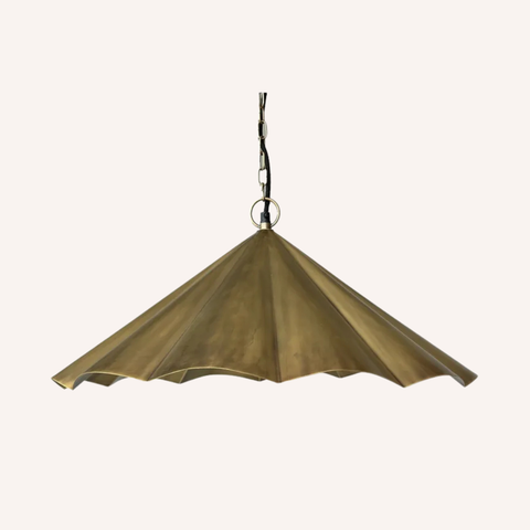A vintage-style brass pendant light shade with a pleated, fan-like design, suspended from a dark metal chain against a plain off-white background.