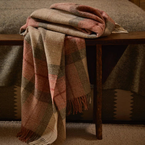 Skye Coral NZ Wool Throw styled on the end of a bed