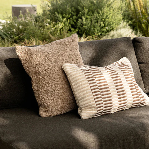Sol Cushion in Terracotta styled outdoors on a lounge chair