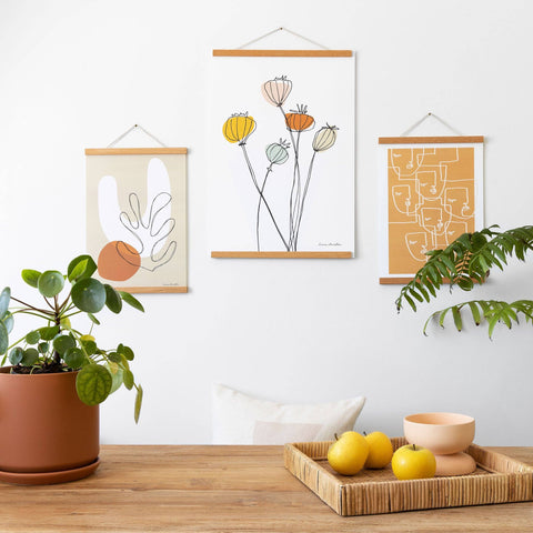 Solid teak magnetic print frame holding an art print on wall