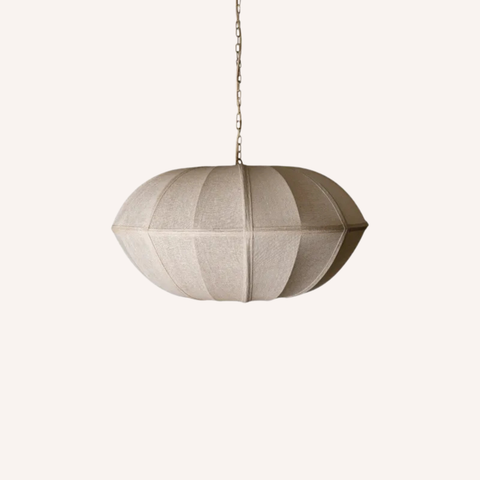 A modern pendant light with a textured, ribbed fabric shade in a warm taupe-beige color, suspended by a thin metal chain against a solid off-white background.