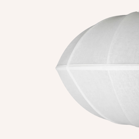 A close-up of a white fabric dome-shaped product, possibly a lampshade or decorative cushion, against a solid off-white background.