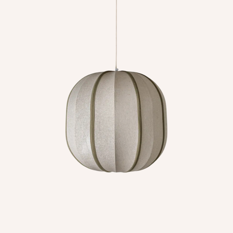 A modern spherical pendant light with a textured beige fabric shade and dark olive green vertical accent bands, suspended by a thin cord against a solid off-white background.