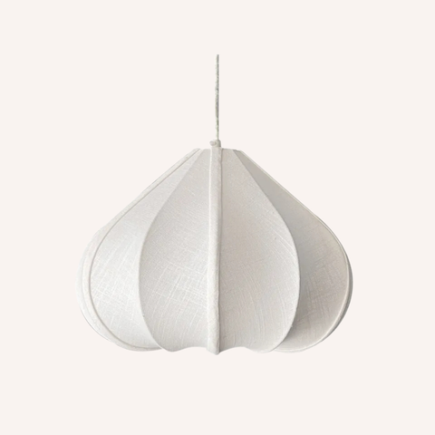 A white fabric pendant light with a textured linen-like surface, featuring a teardrop shape with vertical pleats and a thin hanging cord, shown against a solid off-white background.