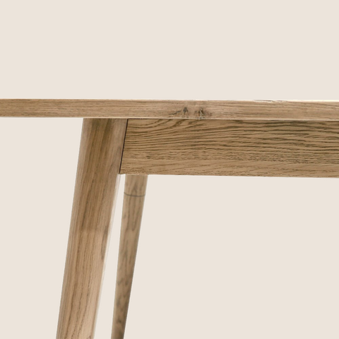 Vanessa Natural dining table side detail showing angular leg and oak grain