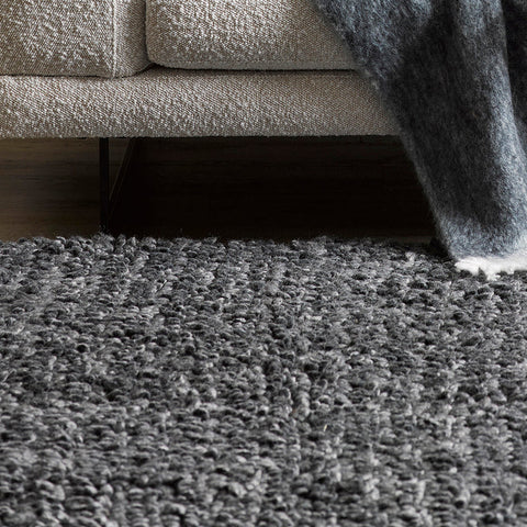 Wanaka Rug in dark grey styled in a living room setting