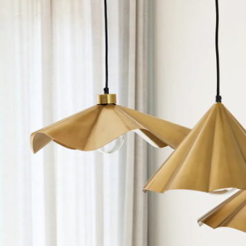 Waved Pendant styled in a room setting, gold finish