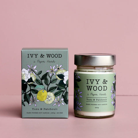 IVY & WOOD candle and packaging on a pink background