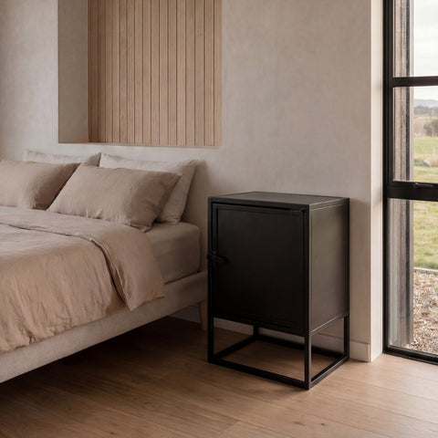 Modern bedroom with a bed and a black nightstand next to a window.
