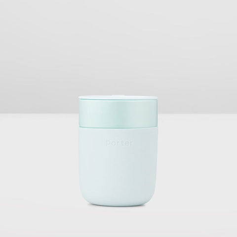 A light mint green portable coffee maker with a matching lid, featuring the Porter brand name embossed on the front, set against a clean, light gray background.