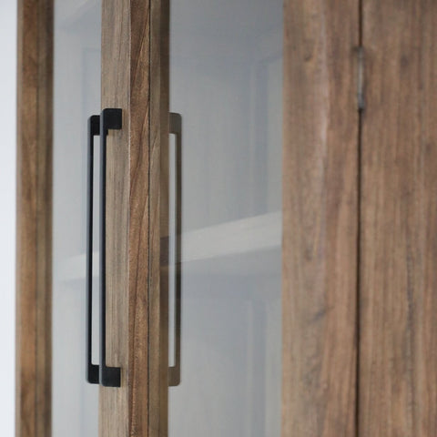 glass cabinet styled with ceramics and books in a contemporary living room