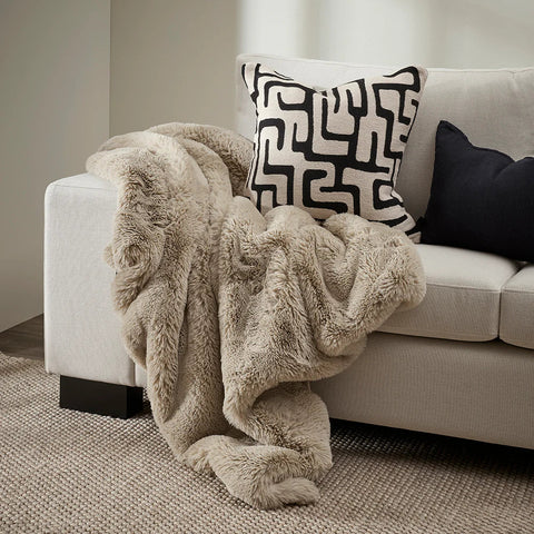 Pelage Throw in Taupe faux fur styled draped over a sofa